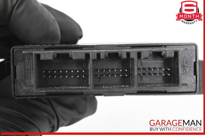 Black electronic component held by a gloved hand with 'Garageman' branding in the corner.
